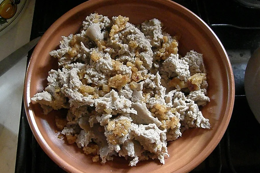 A bowl of ajdovi žganci, buckwheat crumbles topped with cracklings